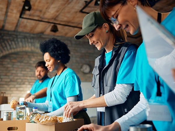 Volunteers in blue vests working together at a community event