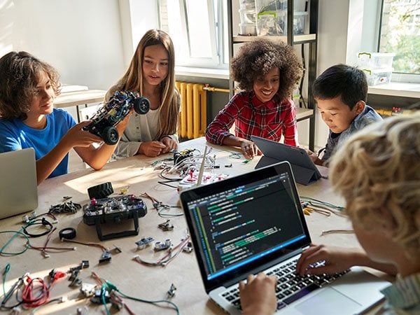 Diverse children working together on a robotics and coding project